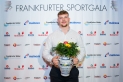 <p>Diskuswerfer und Frankfurter Nachwuchssportler des Jahres Marius Karges posiert vor der Pressewand der Frankfurter Sportgala mit seinem Siegerbembel und Blumen.</p>