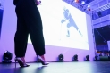<p>Auf der abgedunkelten Bühne der Frankfurter Sportgala wird der Trailer zur Ehrung der Frankfurter Mannschaft des Jahres national gezeigt, im Vordergrund im Detail die silbernen Schuhe von Moderatorin Julia Nestle</p>