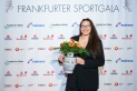 <p>Diskuswerferin und Frankfurter Nachwuchssportlerin des Jahres Curly Brown posiert vor der Pressewand der Frankfurter Sportgala mit Siegerbembeln und Blumen.</p>